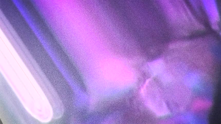Warped footage of reflected purple and violet lights caught on vintage film