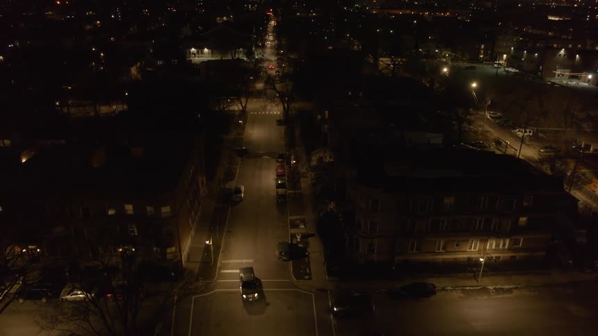 Cars driving on the empty streets of a small town at night