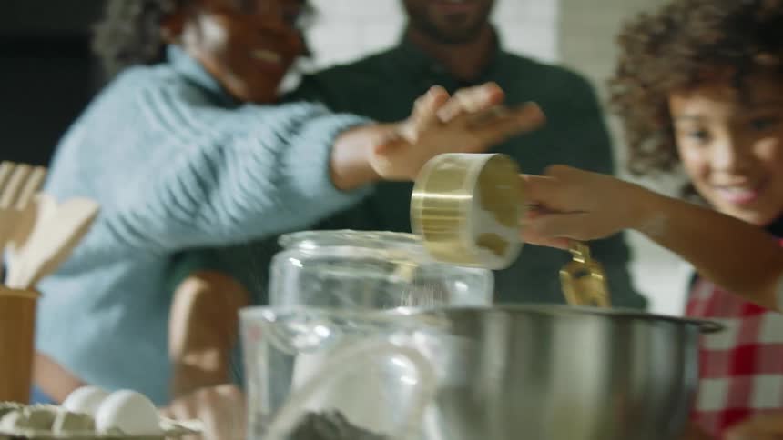 Family have fun cooking together in the kitchen at home