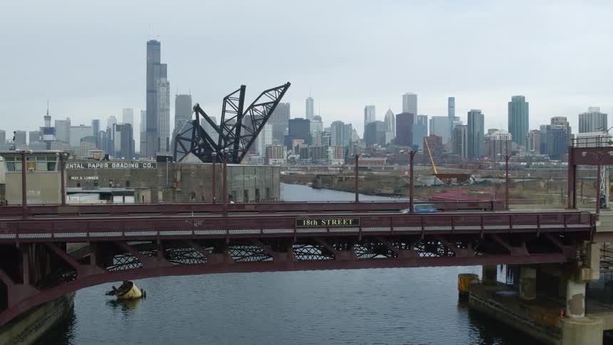Vehicles drive over the bridge near the city