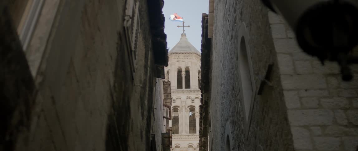 Beyond a dark alley is a tall tower