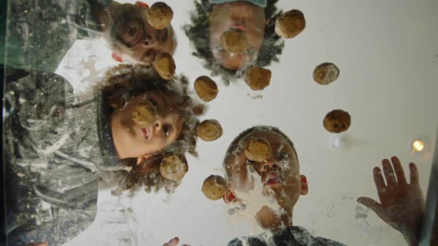 A family place balls of cookie dough on the glass table