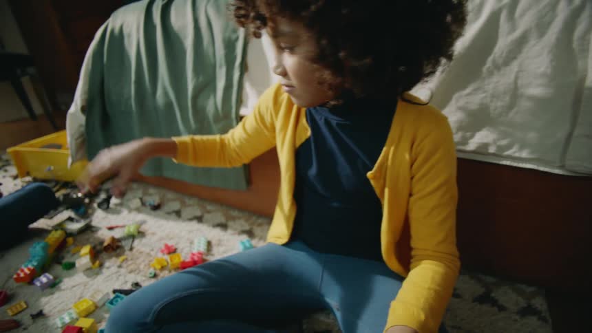 Two children are sitting on the floor playing with toys