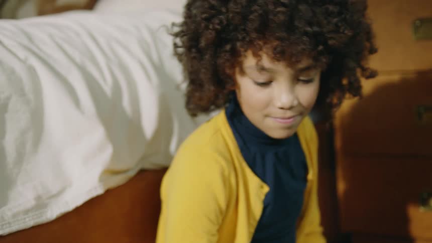 Girl sitting on the bedroom floor playing with toys with his brother