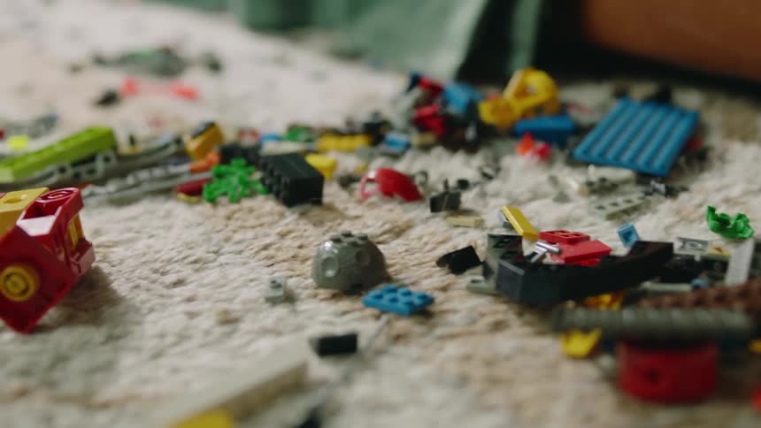 Lego toys and pieces strewn about the rug and floor of a childs room