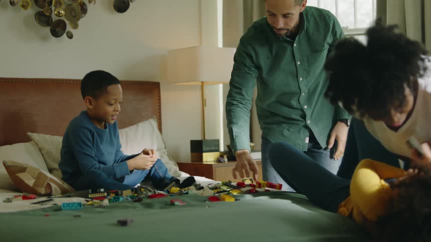 Family playing on bed