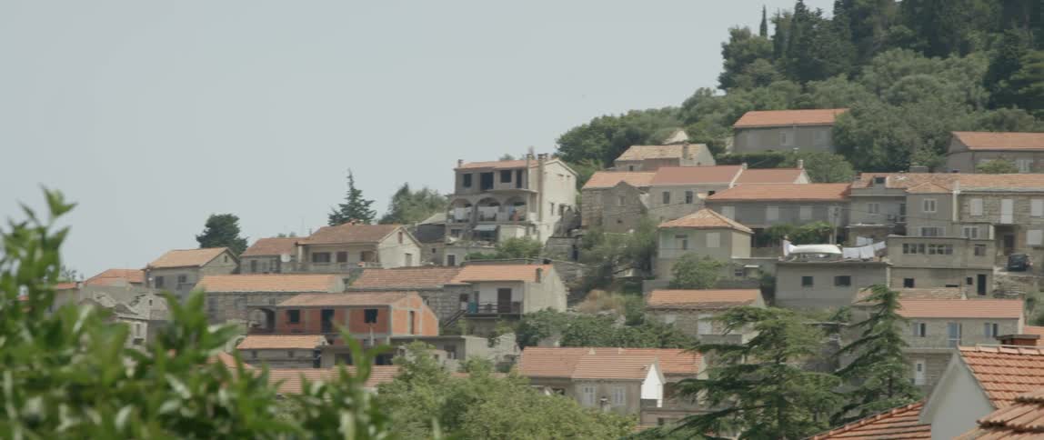 Houses sit on a mountainside in the day time
