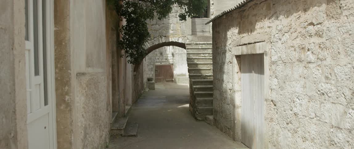 A passage through connected stone buildings is shown