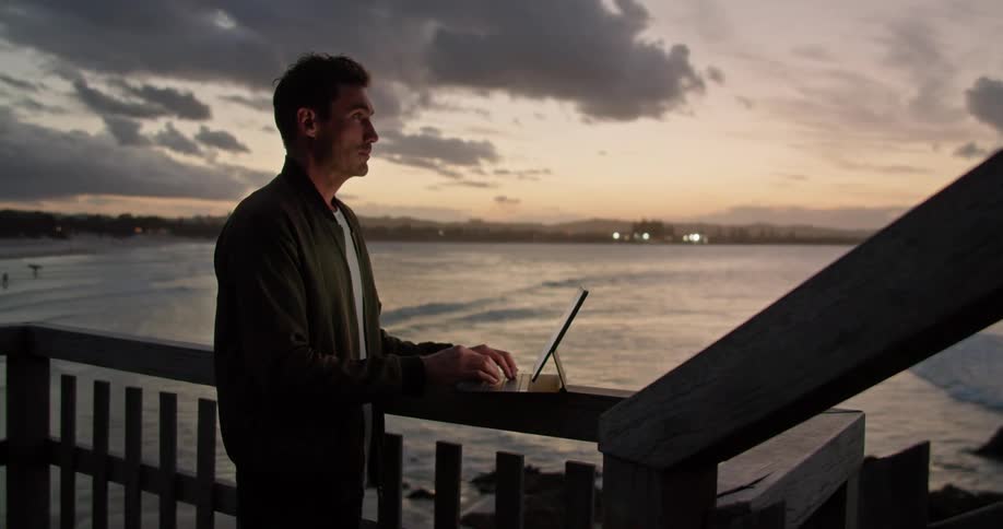 A man is using a laptop on his terrace