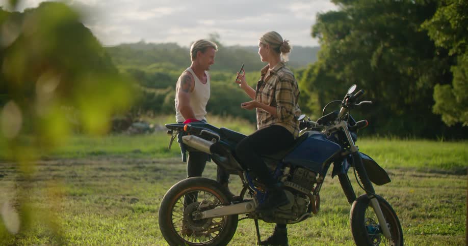 A man and woman talk by the scooter
