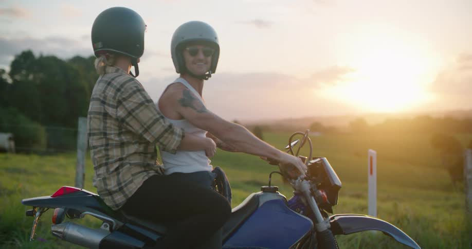 A man and woman pull up on a motorcycle