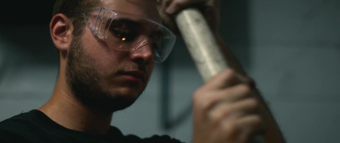 An employee grinding a metal rod in a shop