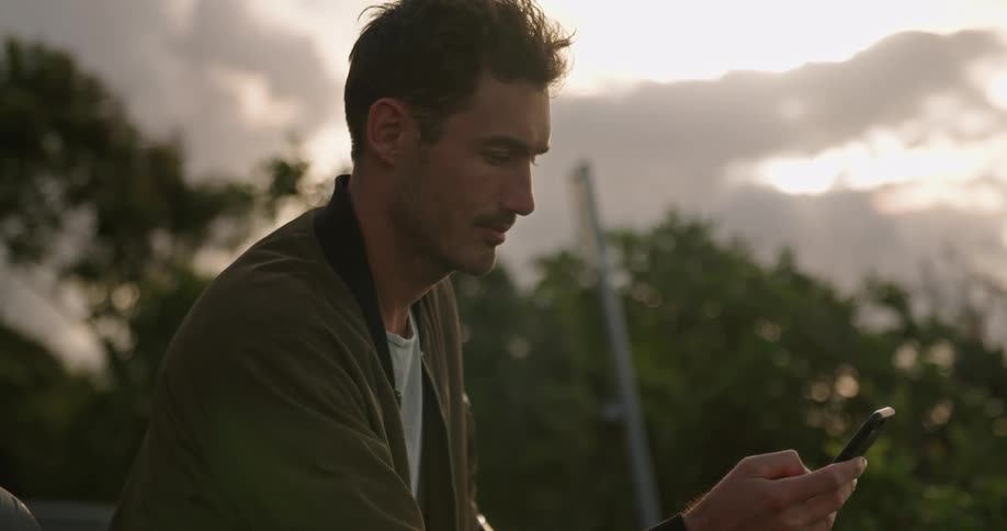 A man is outside making a call on his cell phone