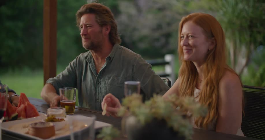 A view of a man and woman talking outdoors at a table