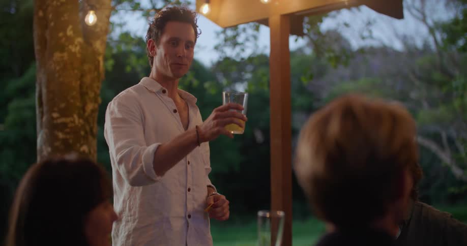 A man is giving a toast at a table