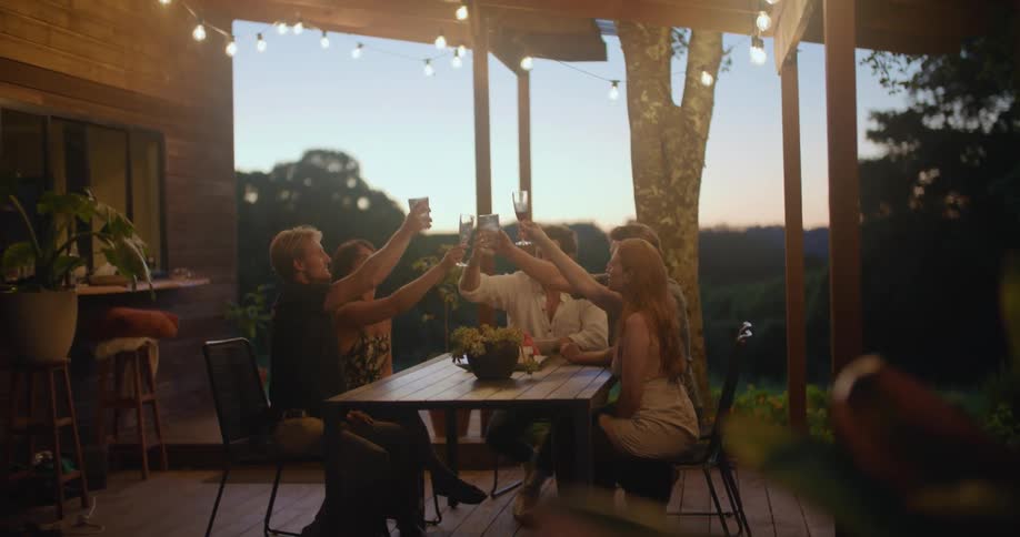 A group of friends have a toast on the porch