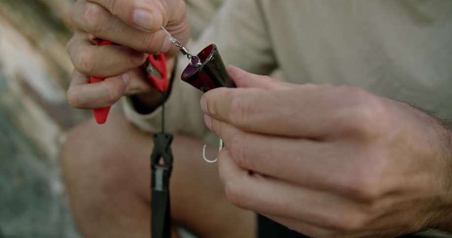 A man is putting a lure on his fishing line