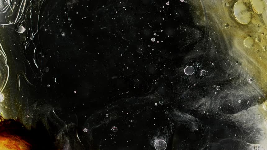 Bubbles flow through black band of orange black and yellow liquid