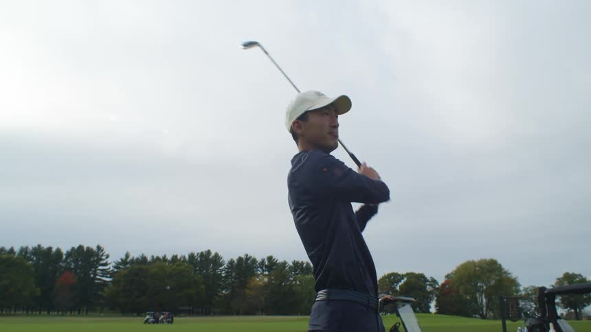 A golfer steps back after swinging to see where the ball lands