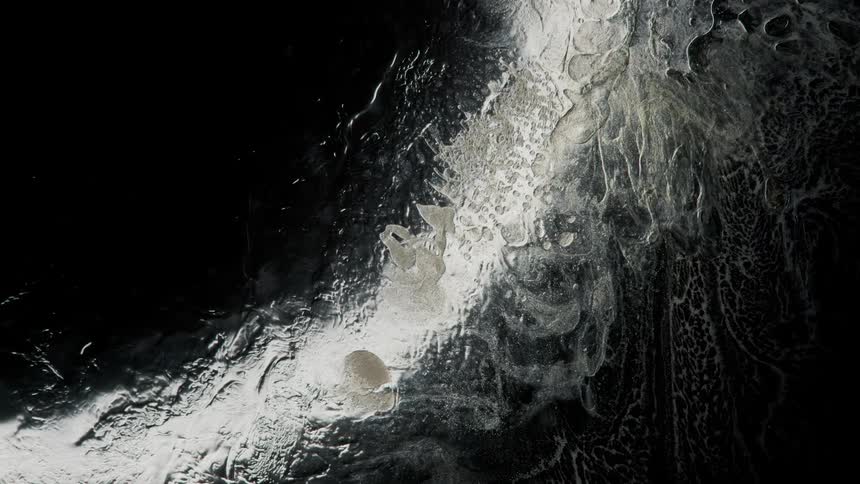 Water stained with white ink flowin on a sheet of glass against a black background