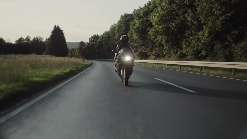 A motorcycle races down the road on a cloudy day
