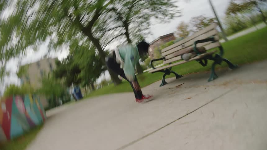 Man performs hand stand on park bench before jumping down onto his feet