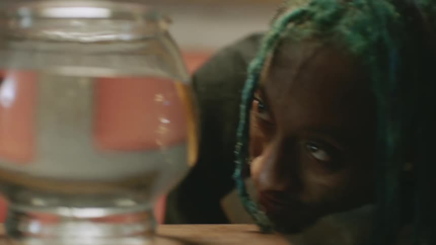 Man and woman watch fish in fish bowl