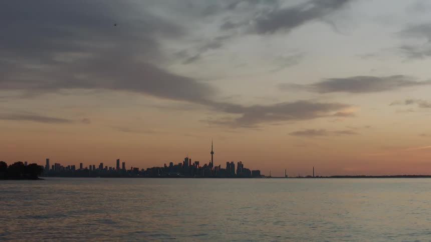 Mist covers city skyscrapers sitting against red sky