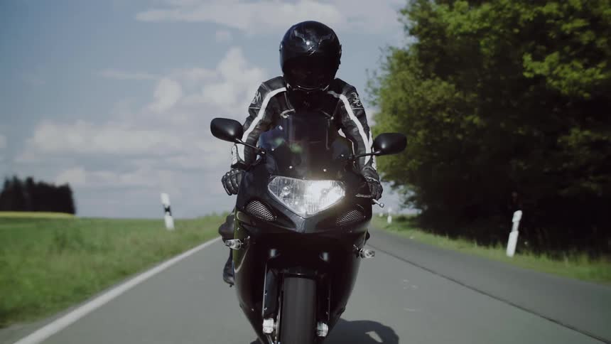 A person rides a motorcycle down a street