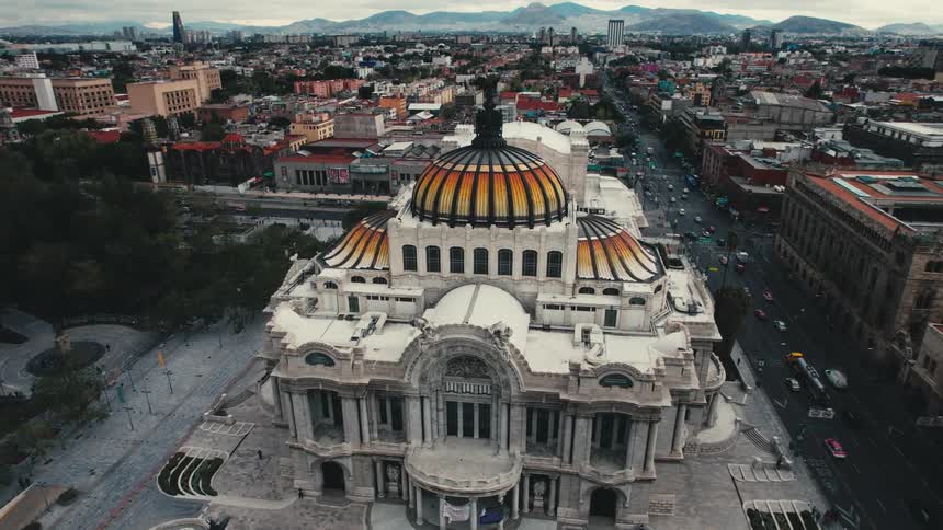 Aerial view of city landmark next to highways on which vehicles drive in the city center