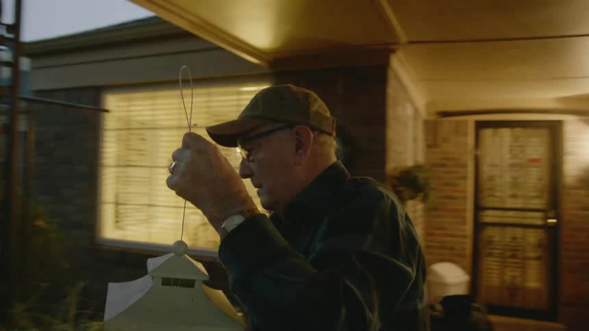 Elderly man moving lantern
