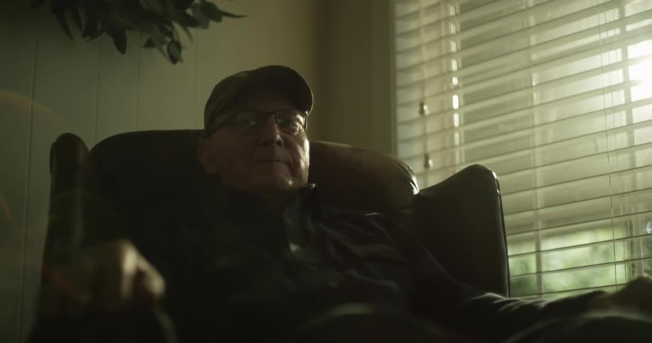 A man sits on his chair by the window