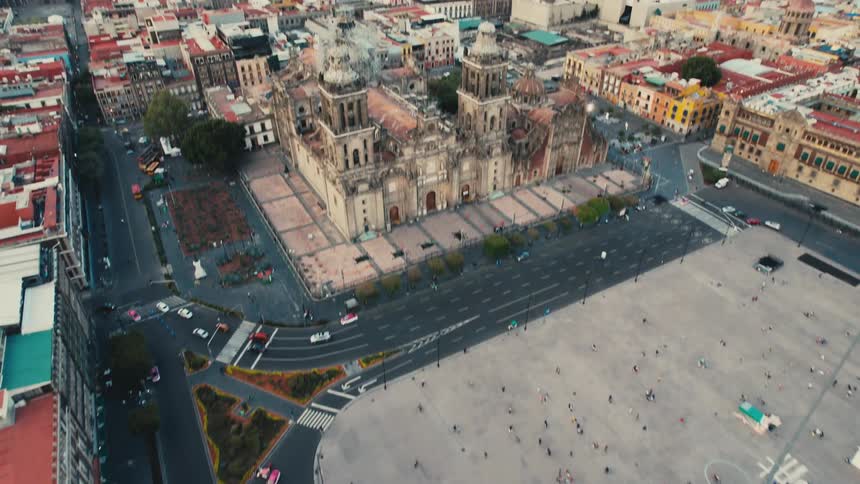 Aerial view of people walk around in city square next to landmark and highways