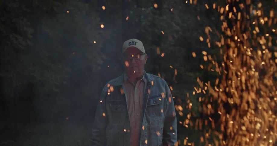 A man stands in front of a large flame