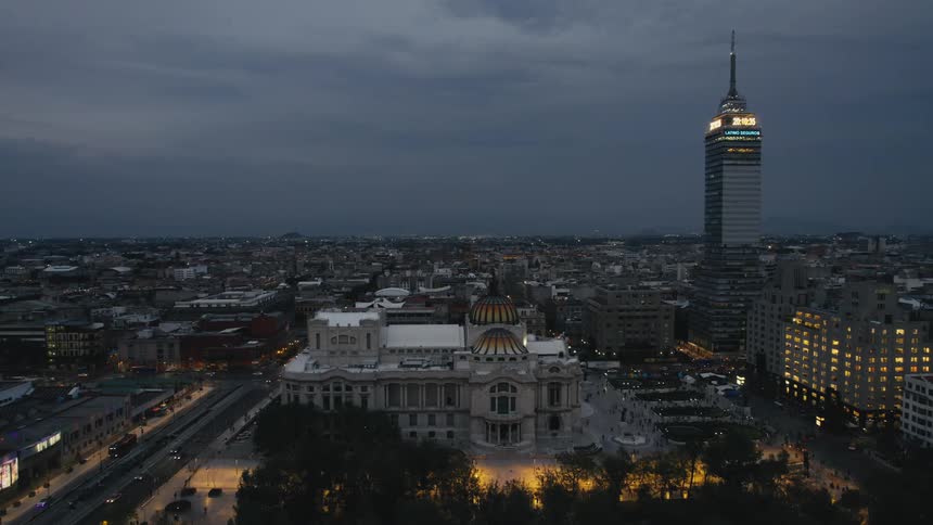 Aerial view of city center with illuminated buildings at dusk