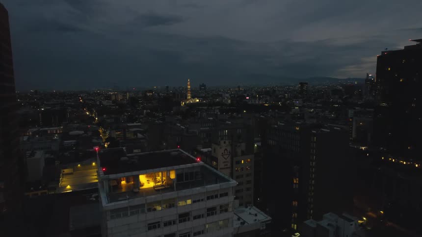 Lights come on in a city as day turns to night