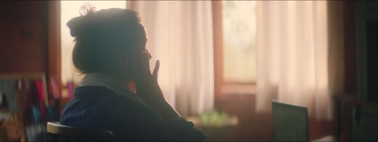 Stressed woman sitting in front of a computer rubs her face and neck