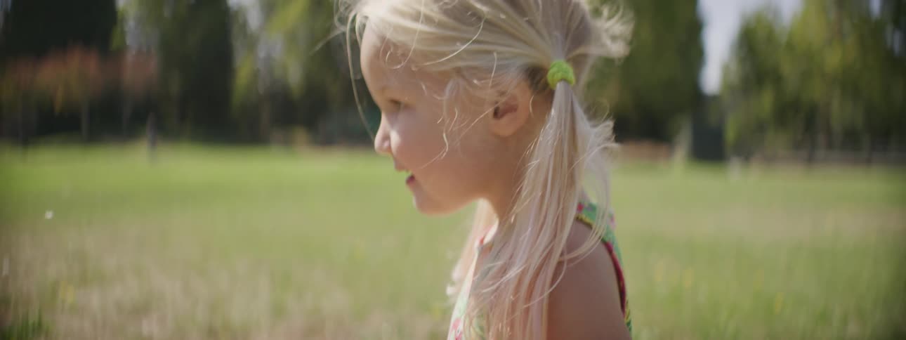 A child playing with a flower outdoors