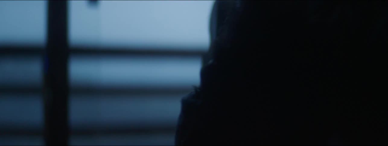 Bearded man with his head hanging over a couch in the dimly lit living room