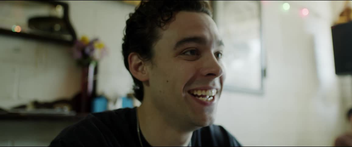 A man laughs and gestures with his hands while talking