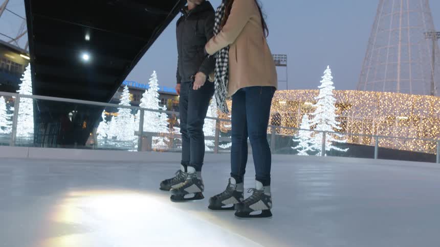 Couple play ice skating on the winter night