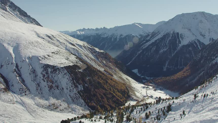 A mountain valley covered in snow during the day