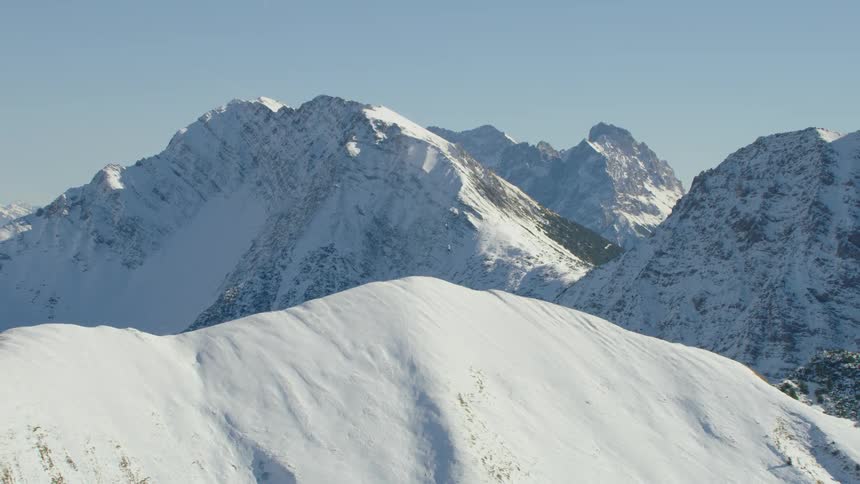 A snowy mountain range under a clear blue sky