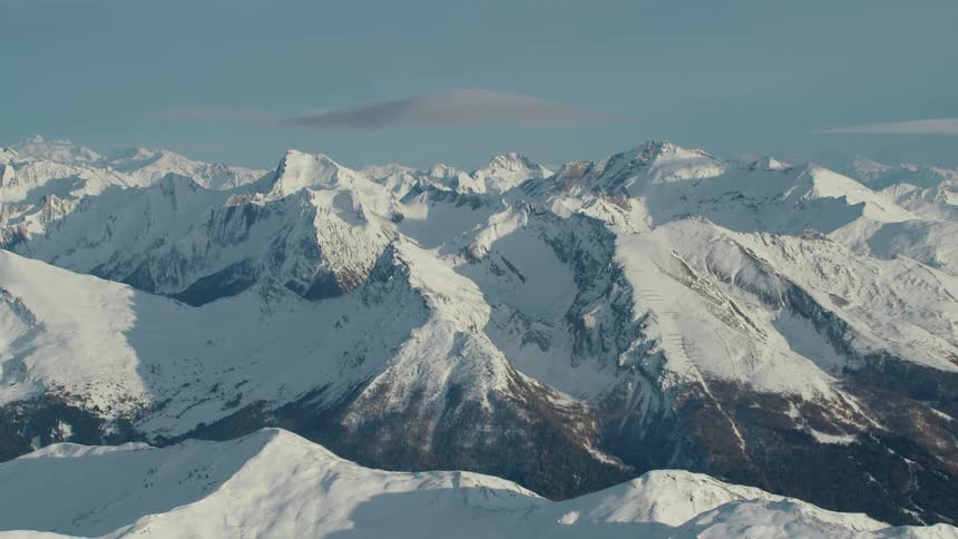 Sunlight shining on snow covered mountain peaks in the wilderness