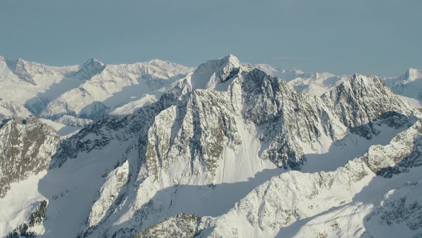 A snow covered mountain range during the day