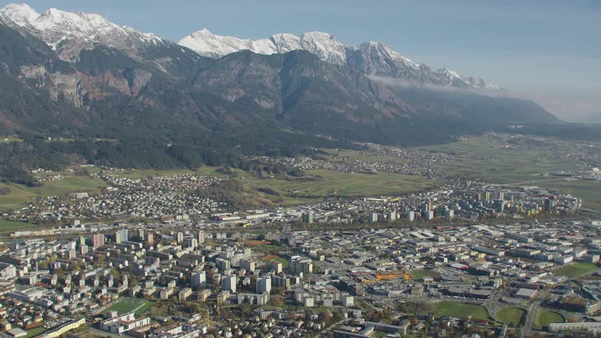The city of innsbruck in austria sprawled out beneath the mountains