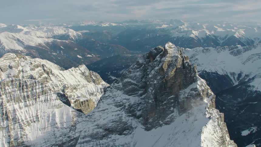 An aerial view of a mountain range with snow on it
