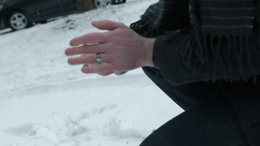A woman forms a snowball with her hands