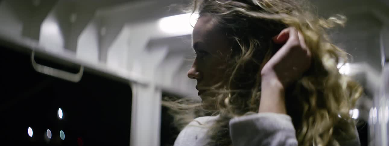 A person with curly hair blowing in the wind