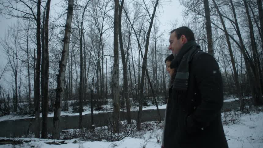 A couple walks through the snow